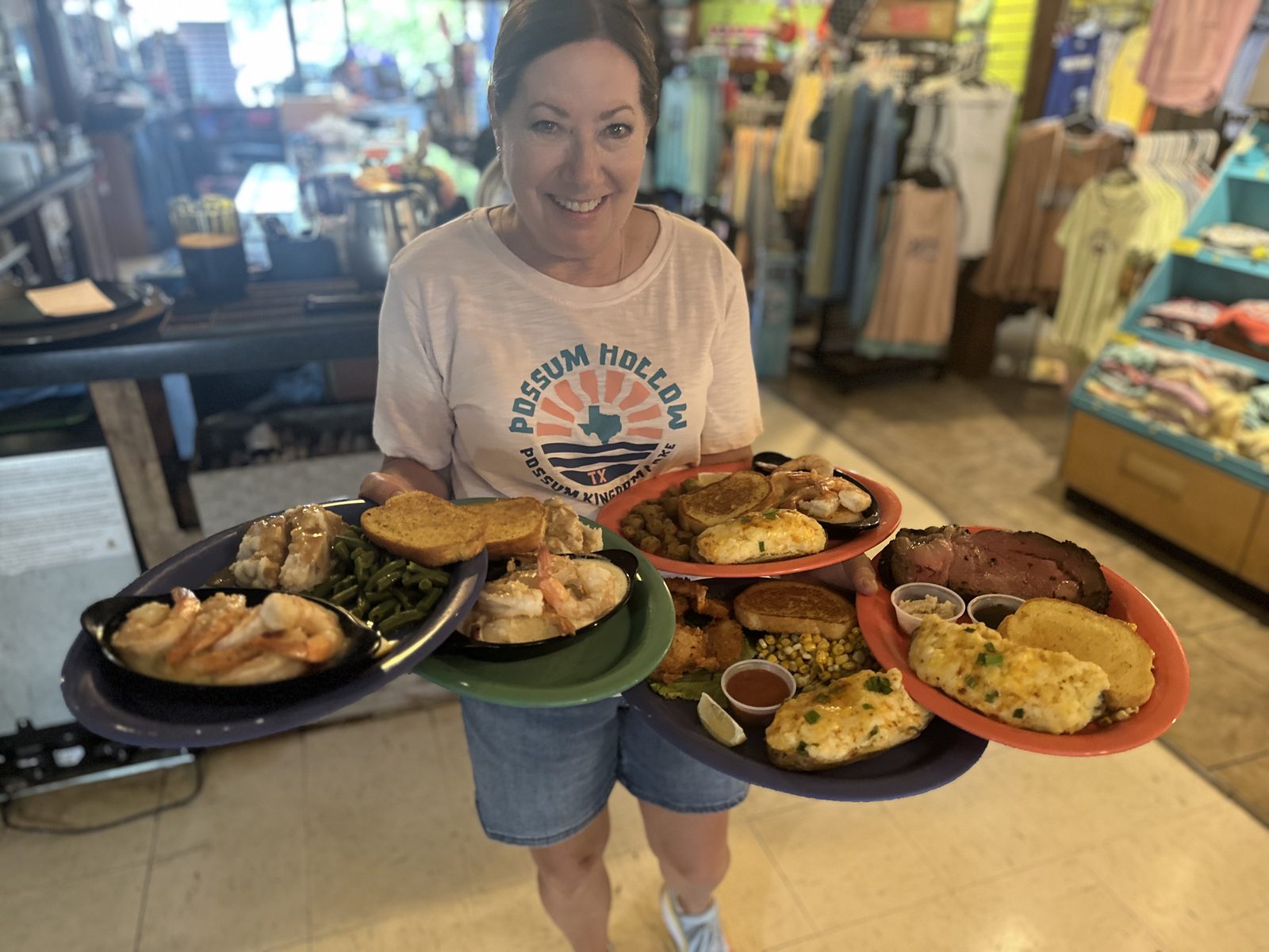 Possum Hollow Lodge server carrying platters of shrimp, prime rib, and sides